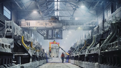 Un homme marche dans une usine d'aluminium