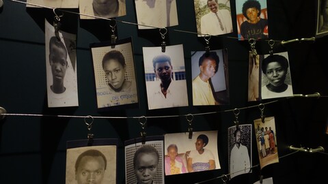 Des photos sont accrochées à des câbles au mur.