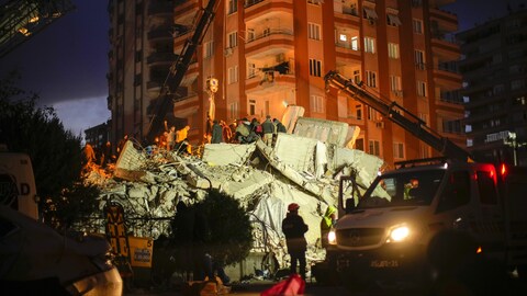 عمال الإنقاذ يبحثون ليلاً عن ناجين بين أنقاض أحد المباني في مدينة أضنة في جنوب تركيا.