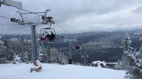 Des skieurs sur une remontée mécanique du Mont-Sainte-Anne, en hiver.