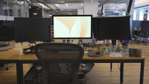 Un poste de travail sans employé où on voit un écran d'ordinateur ouvert.