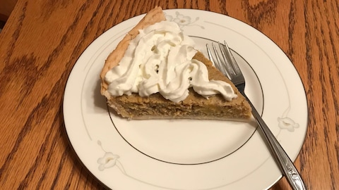 Dans une assiette sur un morceau de tarte à la citrouille avec de la crème fouettée et une fourchette. Dans une assiette sur un morceau de tarte à la citrouille avec de la crème fouettée et une fourchette.