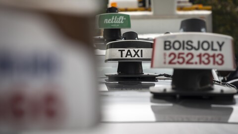 Des enseignes de taxis, dans une rue à Montréal.