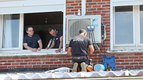 Technicians install an air conditioner at a residence in M&eacute;ricourt, France, on July 19.