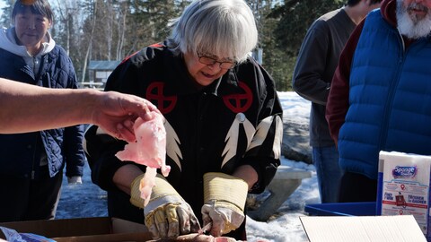 Une personne qui coupe un poisson avec un couteau, le 18 avril 2023, à Yellowknife.