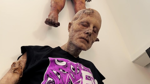 Un mannequin représentant un monstre est accroché sur un mur.