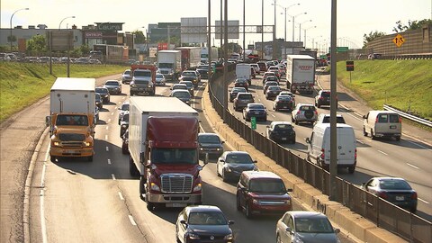 Des camions circulent sur une autoroute.