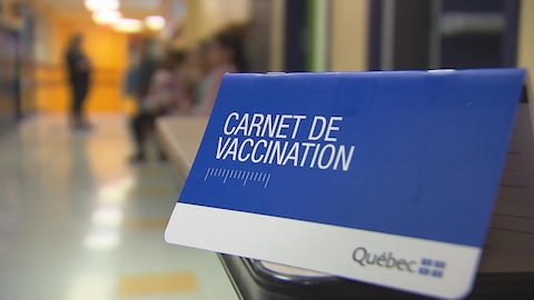 Radio-Canada / Yanic Lapointe Un carnet de vaccination posé sur un pupitre.