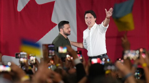 Justin Trudeau salue la foule aux côtés de Volodymyr Zelensky.