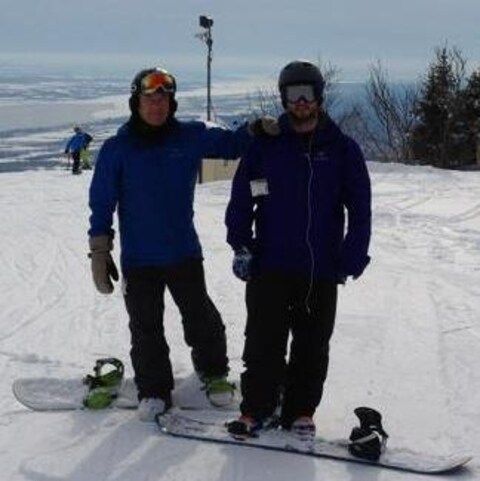 Photo du père et fils faisans du surf des neiges. Photo du père et fils faisans du surf des neiges.
