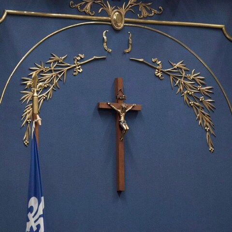 Une croix de bois sous des éléments décoratifs dorés. Une croix de bois sous des éléments décoratifs dorés.