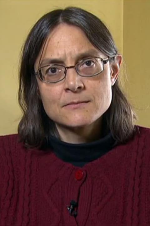 Une femme, assise dans un bureau, regarde vers la caméra. Une femme, assise dans un bureau, regarde vers la caméra.