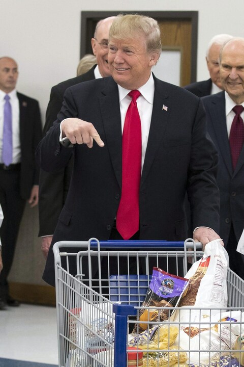 Donald Trump pointe le contenu d'un panier d'épicerie placé devant lui. Donald Trump pointe le contenu d'un panier d'épicerie placé devant lui.