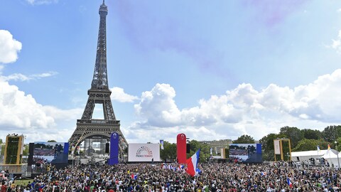 La foule est rassemblée devant la tour Eiffel.