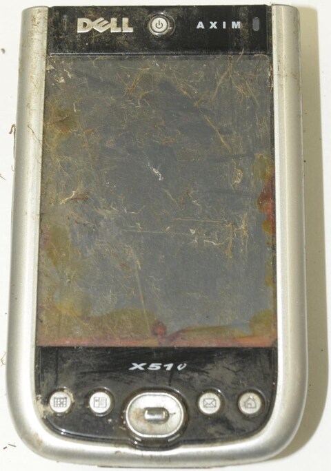 Un appareil semblable à un téléphone cellulaire avec plusieurs égratignures. Un appareil semblable à un téléphone cellulaire avec plusieurs égratignures.