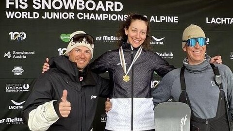 Aurélie Moisan, sa médaille au cou, pose pour la photo avec deux entraîneurs. 