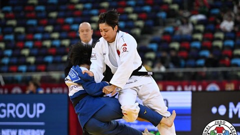 Deux judokas sur un tatami se font une prise.