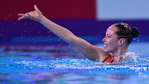 Jacqueline Simoneau tient son bras dans les airs à la surface de l'eau.
