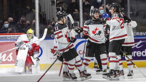 Des joueurs canadiens se rassemblent pour célébrer alors que le gardien tchèque est agenouillé à l'arrière.