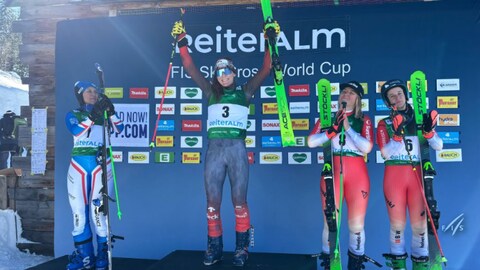 Brittany Phelan lève les bras sur la plus haute marche du podium pour célébrer sa victoire à la Coupe du monde de Reiteralm, en Autriche.