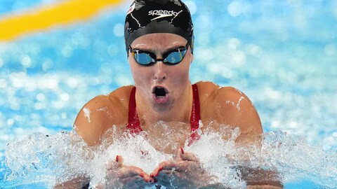 Une nageuse ouvre la bouche pour inspirer pendant une longueur de piscine à la brasse.