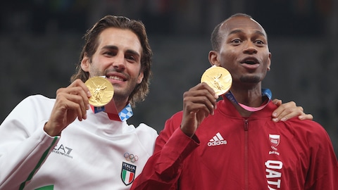 Deux athlètes en survêtement de sport montrent leur médaille d'or.
