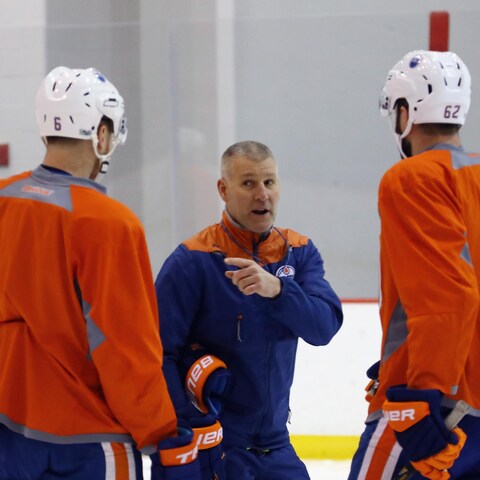 Jim Johnson s'adresse à deux joueurs des Oilers durant un entraînement. Jim Johnson s'adresse à deux joueurs des Oilers durant un entraînement.