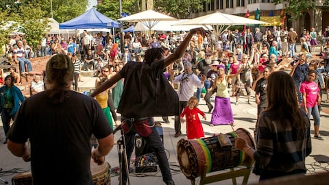 Des gens dansent sur une place lors de l'événement Africa Fest qui célèbre la culture afro-caribéenne à Victoria