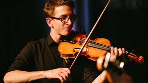Un jeune homme joue du violon.