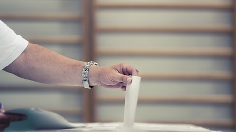 Un électeur place son bulletin de vote dans l'urne.