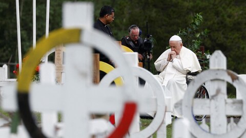 Le pape se recueille devant les tombes d'un cimetière.