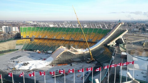 Immense rampe de bois qui débute dans le haut des gradins du stade de football pour se terminer au centre du terrain. 1er décembre 2023.