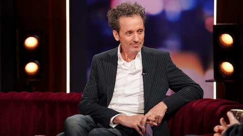 André Sauvé est assis sur le canapé de l'émission Bonsoir bonsoir!