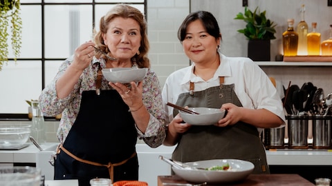 Marina Orsini et Anita Feng posent en cuisine avec un plat asiatique.