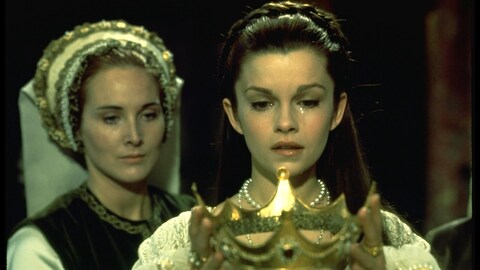 Une femme (Geneviève Bujold) regarde une couronne qu'elle tient dans ses mains.