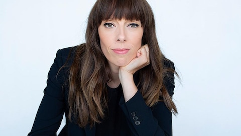 Portrait rapproché de l'autrice et scénariste Marie-Andrée Labbé, avec un haut de complet et les cheveux bruns.