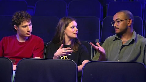 La production est encore jeune / Karine Dufour Les trois personnes sont assises dans une salle de cinéma.