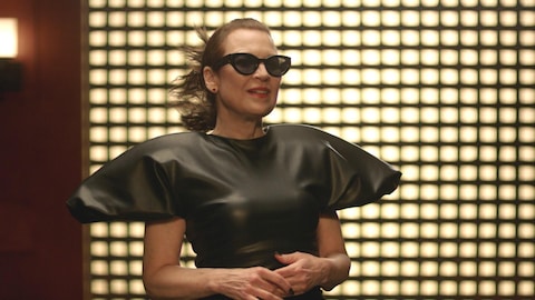 A Média Une femme qui porte des lunettes de soleil et une robe à manches bouffantes.