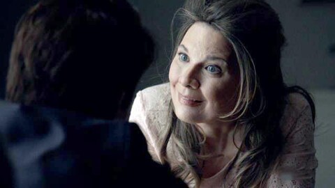 Ses yeux sont très grands ouvert et elle parle à quelqu'un