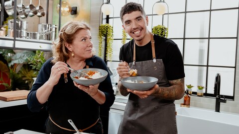 Marina Orsini et Camilo Lapointe-Nascimento posent avec leur plat en cuisine.
