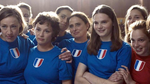 Un groupe de jeunes filles portant l'uniforme de l'équipe de France de football.