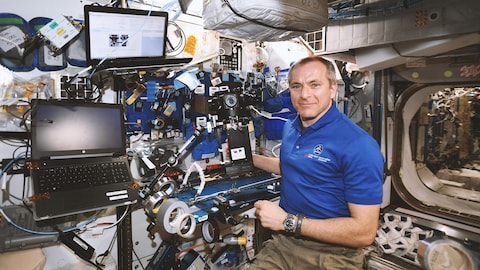 David Saint-Jacques dans la station spatiale qui sourit à la caméra.