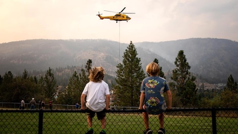 Radio-Canada Deux adolescents regardent un hélicoptère.