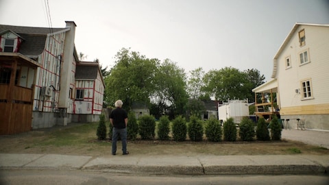 Radio-Canada Un homme devant un terrain vacant entre deux maisons.