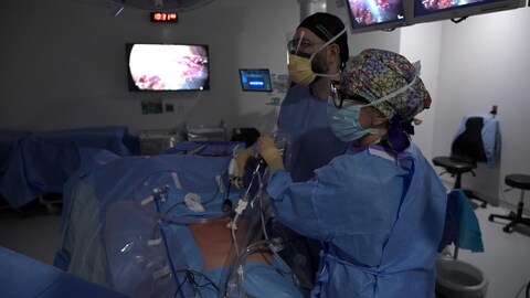 2 médecins qui opèrent un patient.