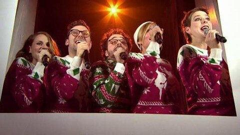 Ils chantent. Ils portent un chandail de Noël.