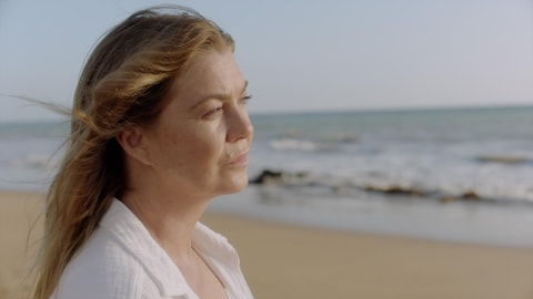 L'actrice Ellen Pompeo regarde au loin sur une plage.