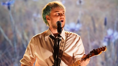 Édouard Tremblay-Grenier chante en jouant de la guitare.