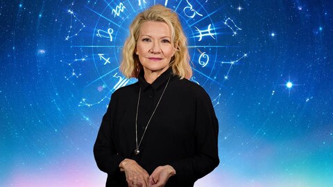 Une femme devant les constellations du zodiaque.