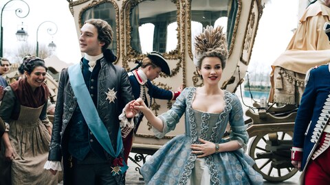 Louis Cunningham (Louis) et Emilia Schüle (Marie Antoinette) sortent d'un carosse royal.